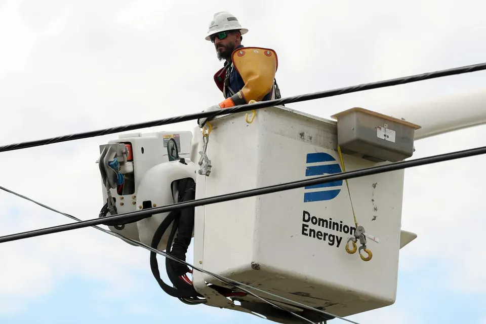 FILE – A Dominion Energy lineman lifts himself up to work on a power line in the aftermath of Hurricane Helene Sunday, Sept. 29, 2024, in North Augusta, S.C. (AP Photo/Artie...