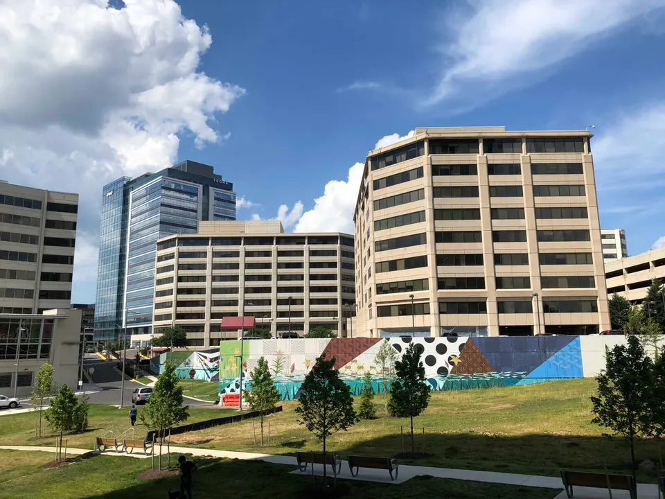 The vacant land south of the Booz Allen Hamilton office building in Tysons Central was turned into a temporary green space with benches and trees (staff photo by Angela Woolsey)