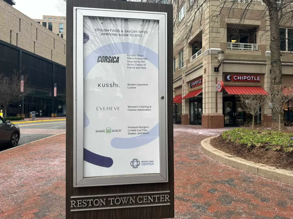 A sign lists upcoming restaurants and retail stores at Reston Town Center (staff photo by Angela Woolsey)