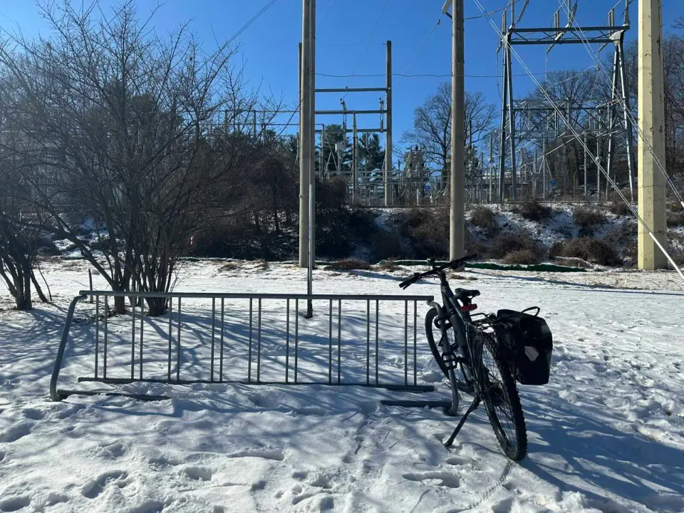 Bicycle parked in snow near Dominion Energy’s Clark substation in Vienna (staff photo by Angela Woolsey)