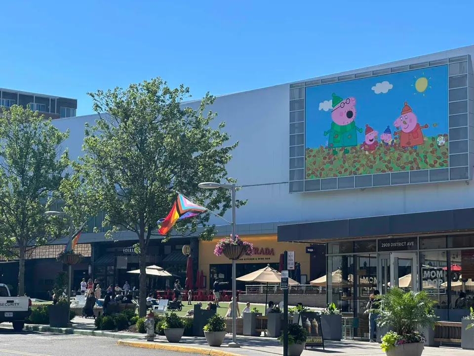 The children’s TV show “Peppa Pig” plays on the outdoor screen at the Mosaic District in Merrifield (staff photo by Angela Woolsey)