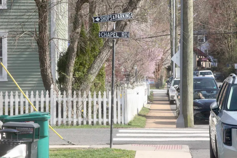 A sign at the Main Street and Chapel Road intersection in Clifton points to shops and parking (staff photo by James Cullum)