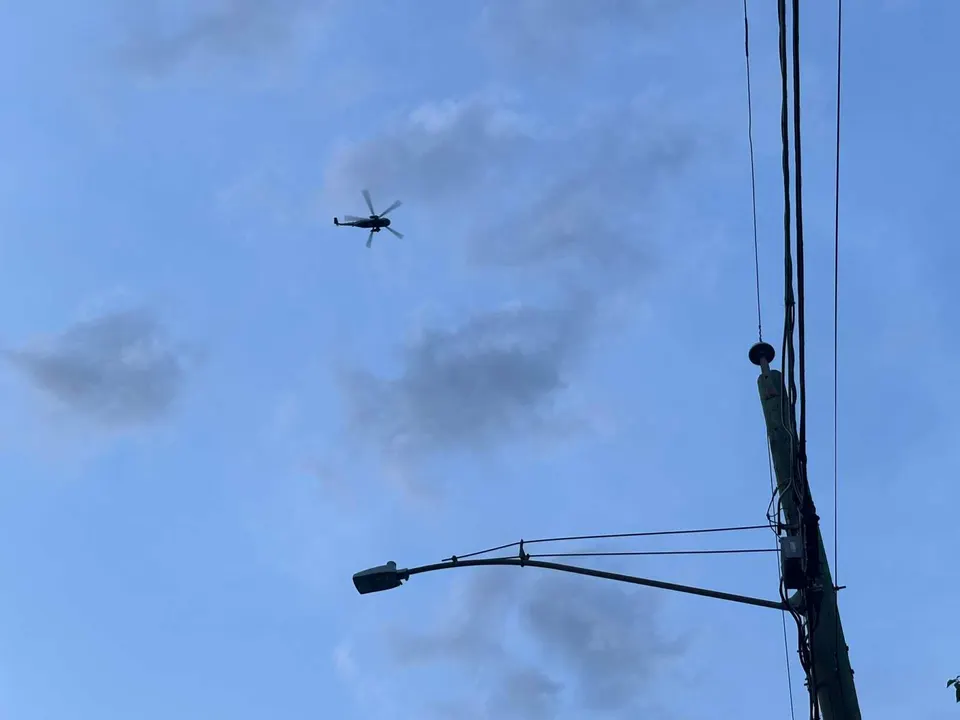 A helicopter passes above a streetlight in Vienna (staff photo by Angela Woolsey)
