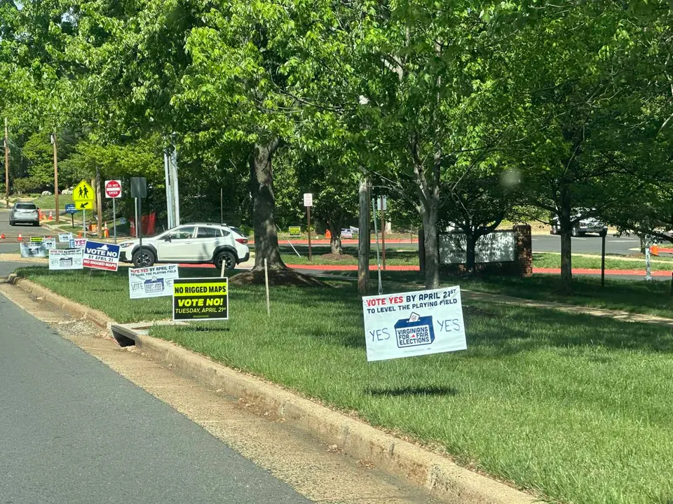 Campaign signs for and against Virginia’s constitutional amendment on redistricting outside Daniels Run Elementary School in Fairfax City (staff photo by Angela Woolsey)