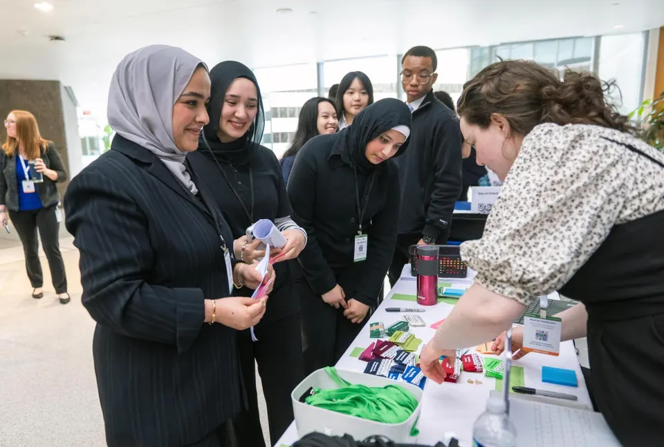 Students at the conference speak with an industry professional at a booth.
