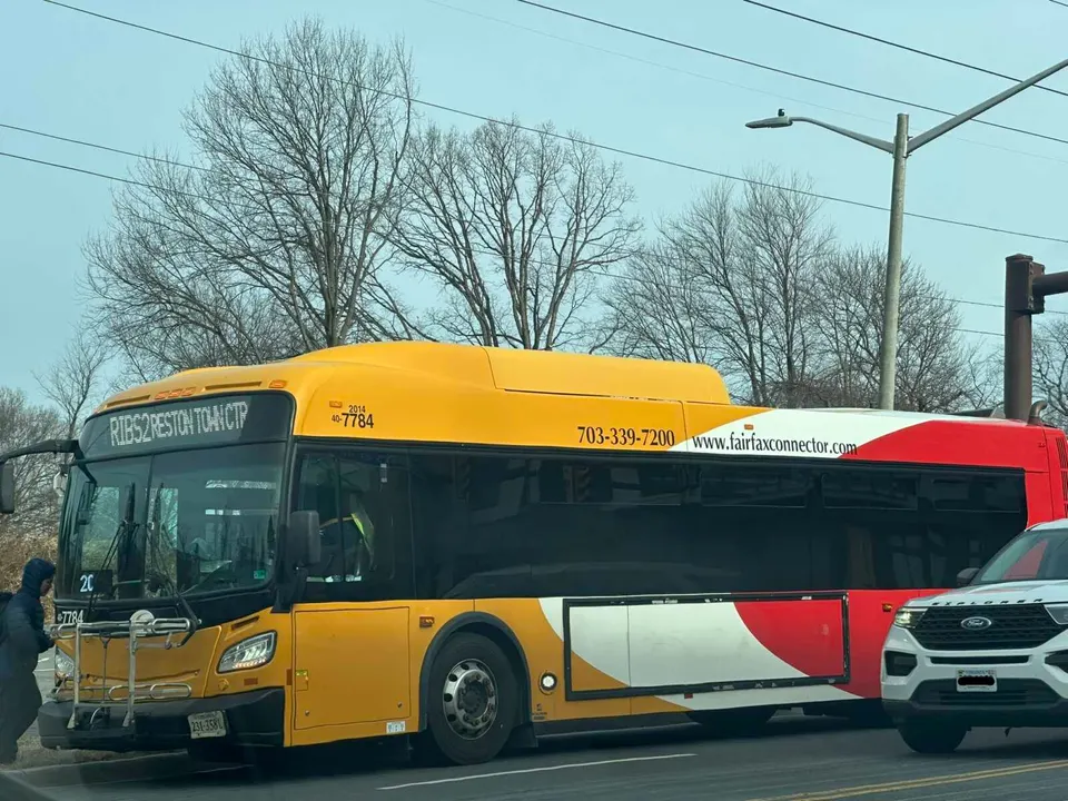 A passenger boards a Fairfax Connector bus at a stop on Sunset Hills Road in Reston (staff photo by Angela Woolsey)