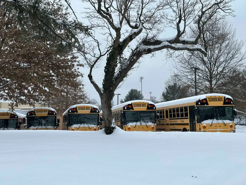 Fairfax County school buses lined up in the snow outside Vienna Elementary School (staff photo by Angela Woolsey)