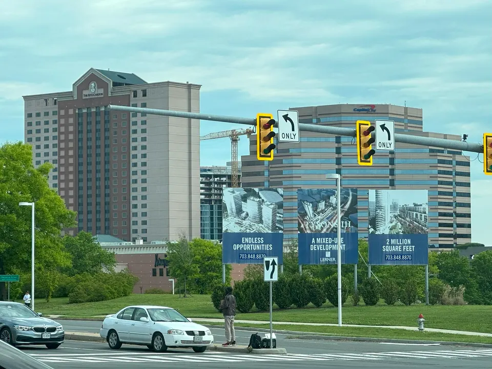 A person can be seen panhandling on the median of International Drive in Tysons (staff photo by Angela Woolsey)