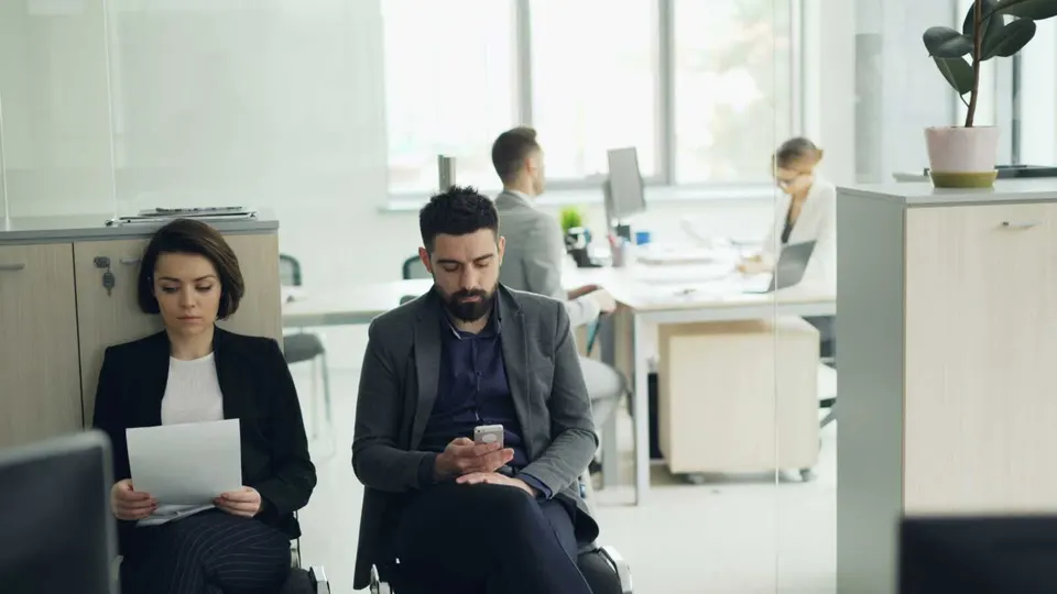 Job candidates waiting for an interview in an office (photo via Vitaly Gariev on Unsplash)