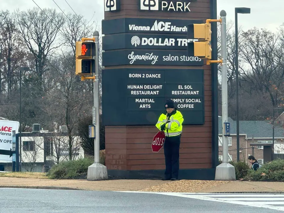 A crossing guard for Thoreau Middle School at the corner of Park Street and Cedar Lane in Vienna (staff photo by Angela Woolsey)