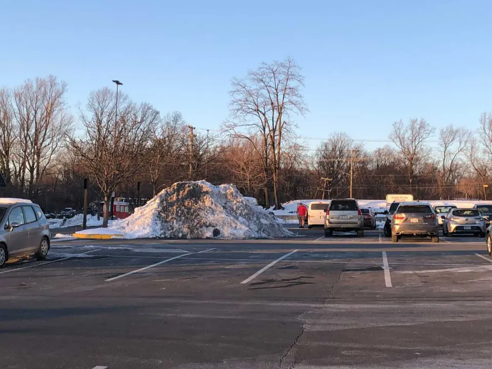 A mound of snow blocks parking spaces in Merrifield’s Providence Place, formerly the Pan Am Shopping Center (photo by Susan Woolsey)