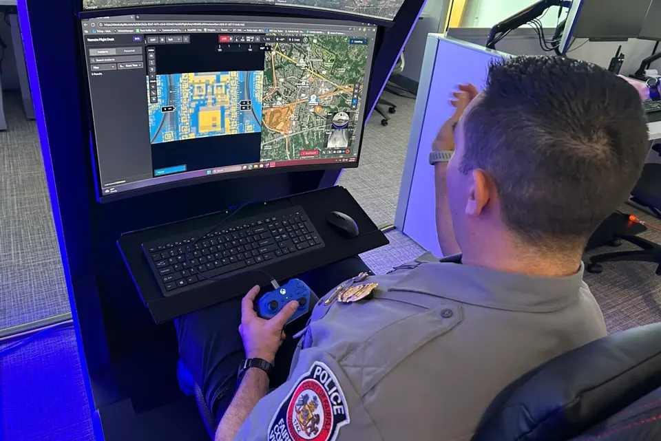 police officer pictured from over the shoulder sitting looking at computer