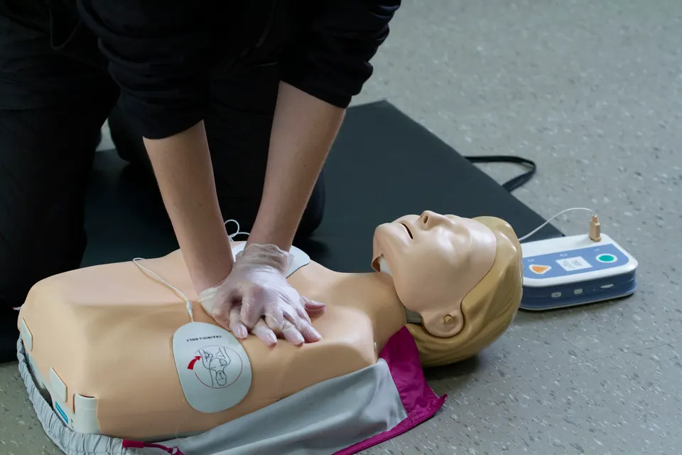 First responce worker demonstrades CPR and proper defibrillator procedure on a manikin.