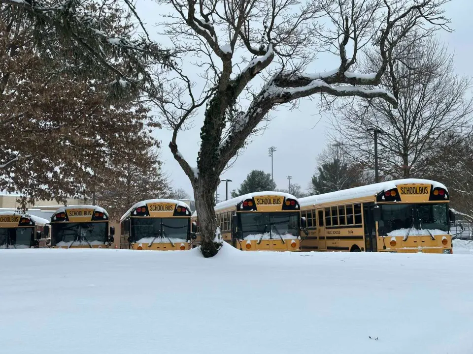 Fairfax County school buses lined up in the snow outside Vienna Elementary School (staff photo by Angela Woolsey)