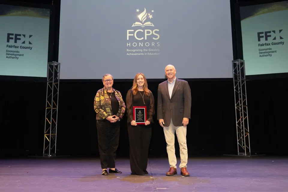 A woman receives an award on a stage