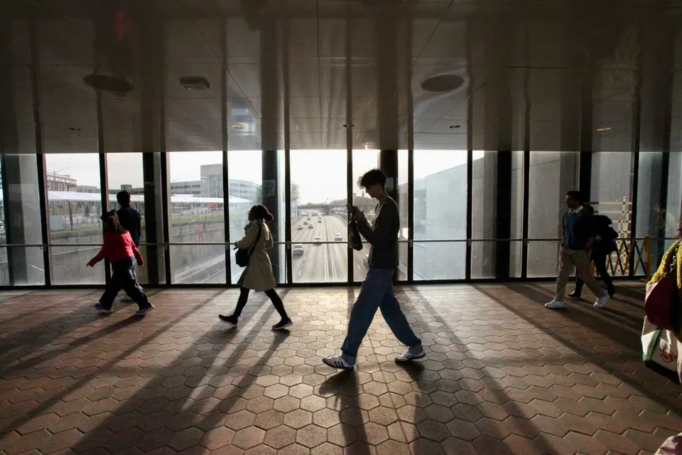 Travelers walk on the pedestrian bridge of the Vienna Metro station (staff photo by James Cullum)