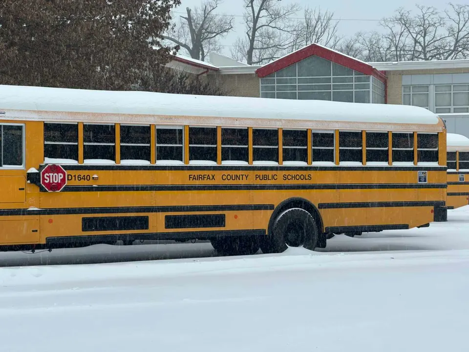 A Fairfax County school bus in the snow outside Vienna Elementary School during Winter Storm Fern (staff photo by Angela Woolsey)