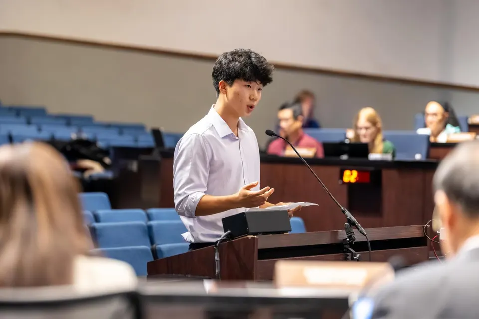 A young man speaks at a podium.