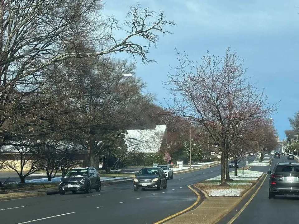 Cars heading west on Route 123 into Vienna with a sprinkling of snow in the median (staff photo by Angela Woolsey)