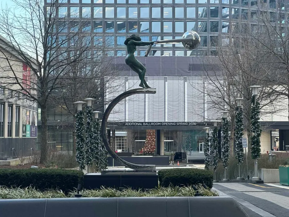 Lorenzo Quinn’s “The Force of Nature” sculpture at Reston Station with winter holiday decor in background (staff photo by Angela Woolsey)