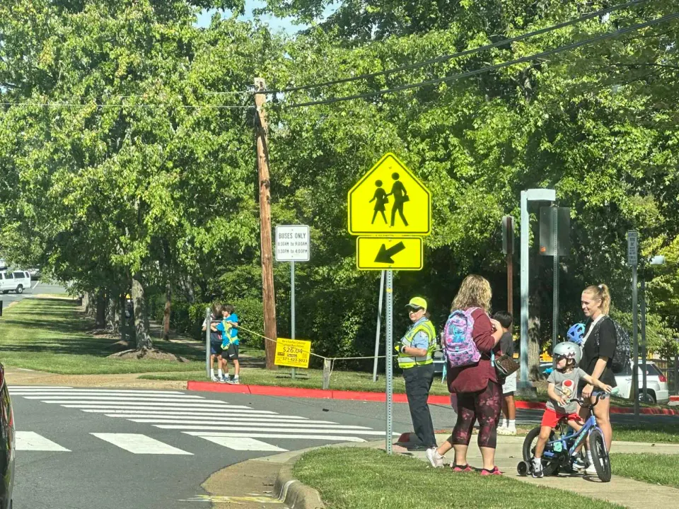 A crossing guard watches a crosswalk outside Daniels Run Elementary School in Fairfax City (staff photo by Angela Woolsey)