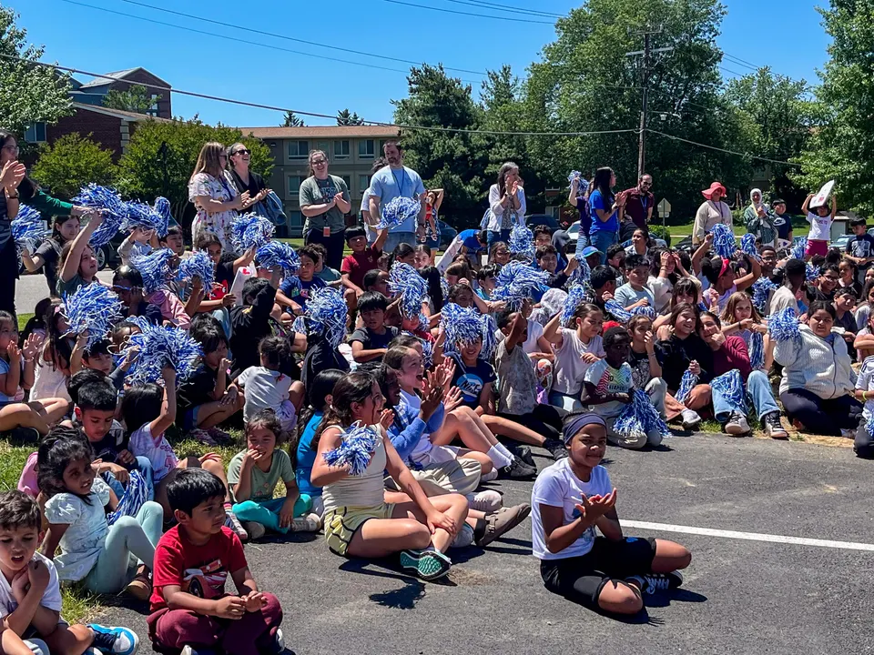 Students celebrate the firefighters waving pompoms.