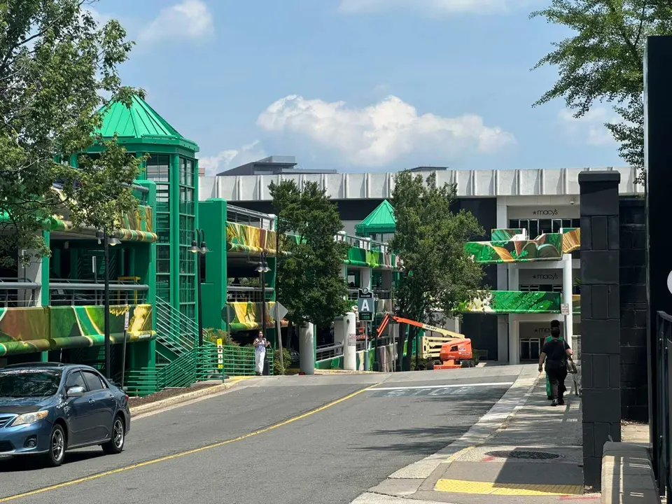 People walking by Tysons Corner Center’s parking garage A near Macy’s (staff photo by Angela Woolsey)