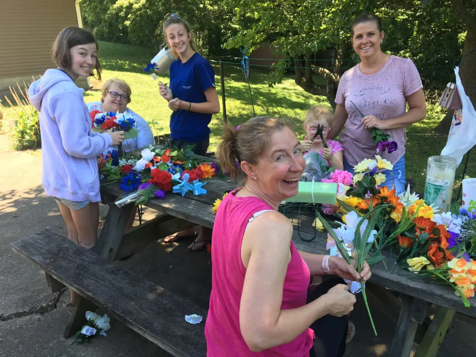 "First we hit the local Walmart and buy scads of artificial flowers, every color in the rainbow..." Family members of the author, Carol McEwen, preparing commemorations for...