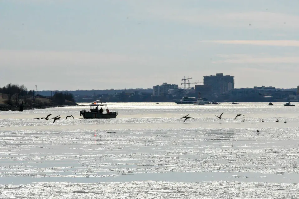 Police and fire boats search the Potomac River after the Jan. 29 mid-air airplane and helicopter collision near Reagan National Airport with the crash site visible in the...