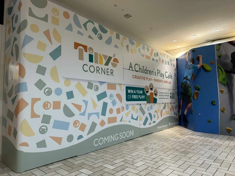 A construction sign announces Tiny’s Corner Play Cafe is coming soon to Tysons Corner Center (staff photo by Angela Woolsey)