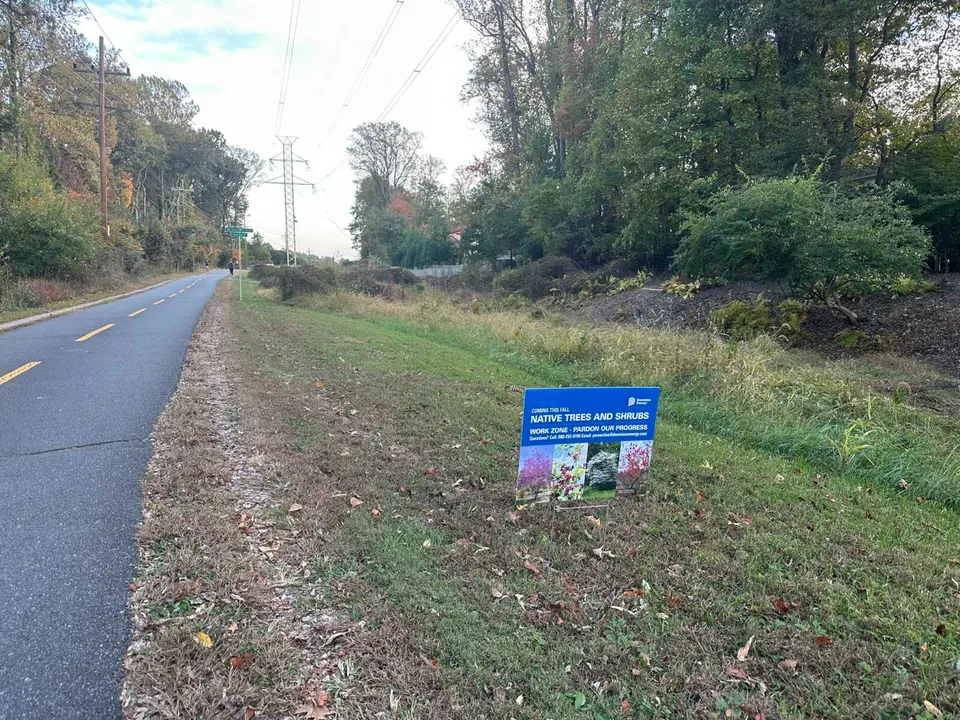 A sign posted in October 2025 tells Washington & Old Dominion Trail users that Dominion Energy will replant a cleared area with native trees and shrubs as invasive species...