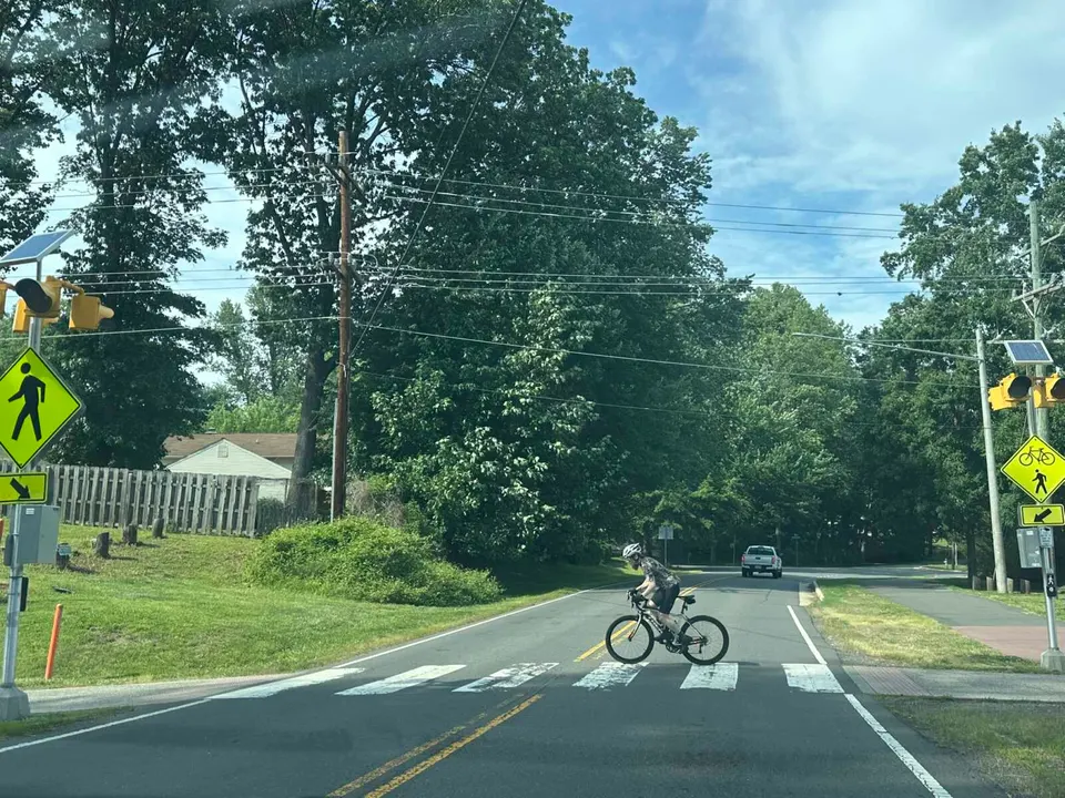 A cyclist crosses Cedar Lane on the Washington & Old Dominion Trail in Dunn Loring (staff photo by Angela Woolsey)