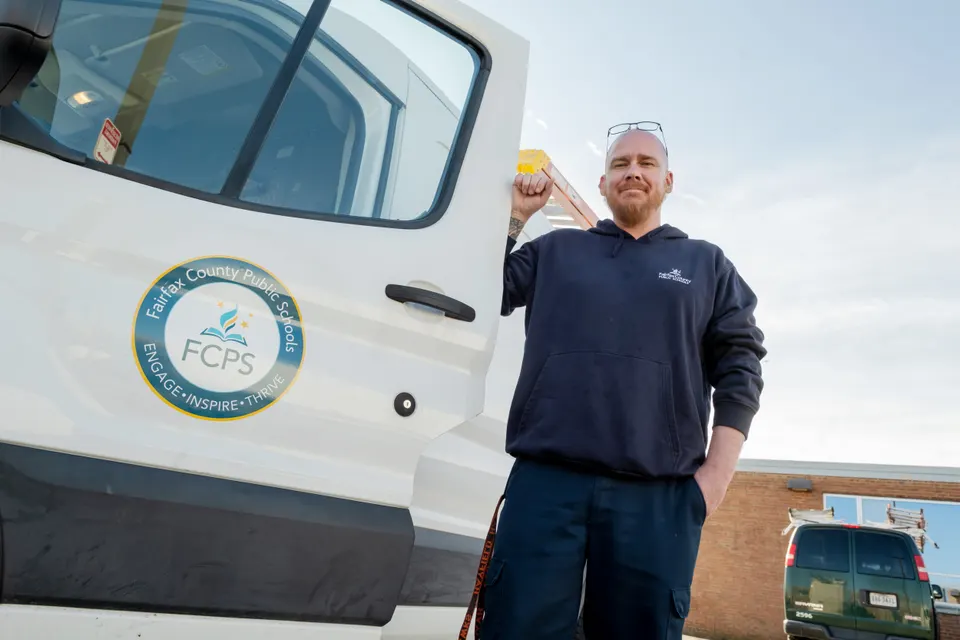 DJ smiling outside of his work vehicle