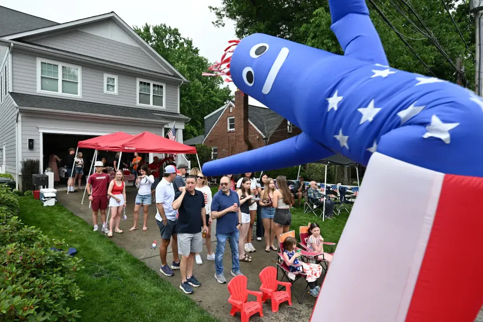 People gather in the front yard of Chris Just’s home to watch a Memorial Day Parade on Monday in Falls Church, Virginia. Photo by Matt McClain. Courtesy Washington Post.