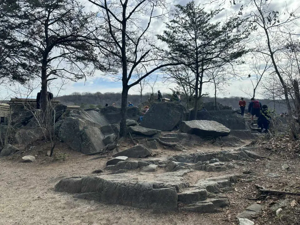 Visitors sit at a rocky overlook in Great Falls Park (staff photo by Angela Woolsey)