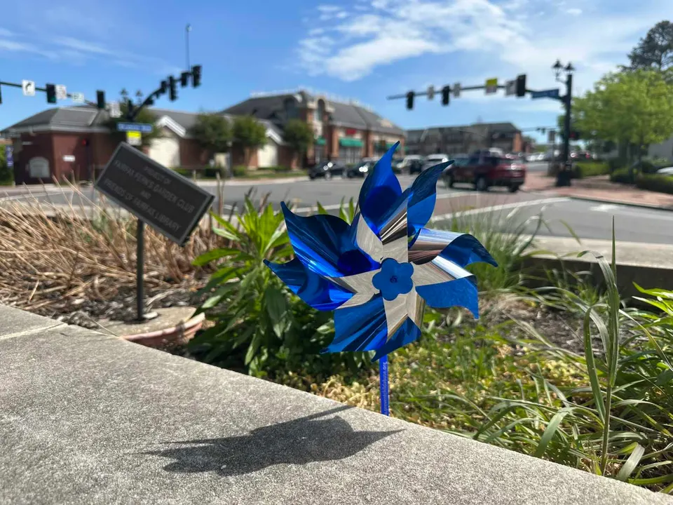 A blue pinwheel in the garden outside the City of Fairfax Regional Library (staff photo by Angela Woolsey)