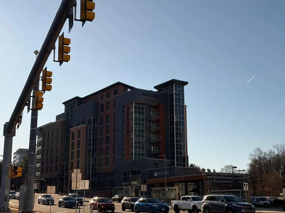 An airplane contrail descending towards Archer Hotel Tysons in Scotts Run (photo by Amy Woolsey)