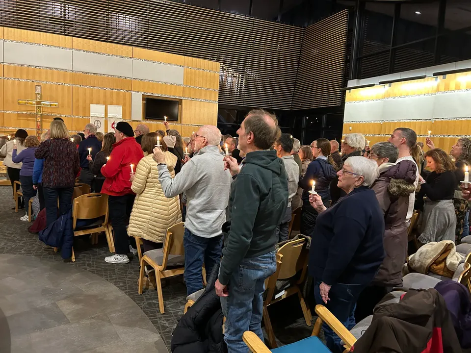 people stand holding candles