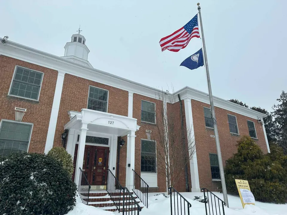 Flags wave outside Vienna Town Hall in snow (staff photo by Angela Woolsey)