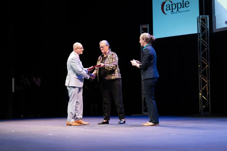 A man receives an award on stage.
