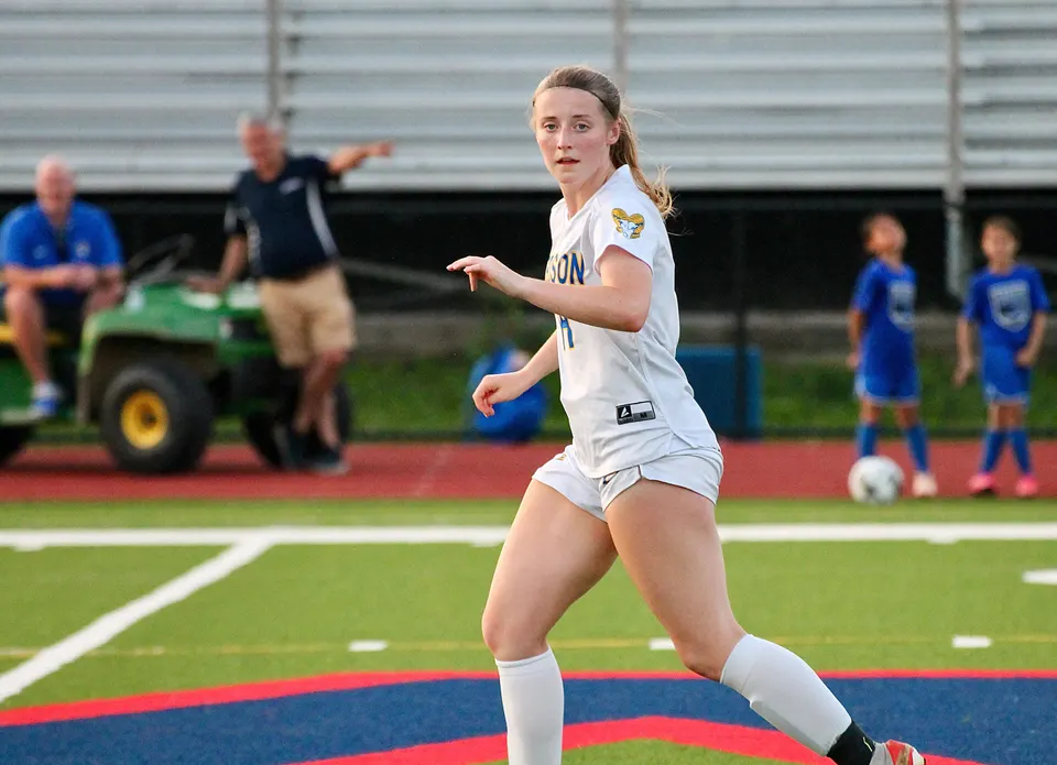 Abby Huisman runs in uniform on the soccer field.