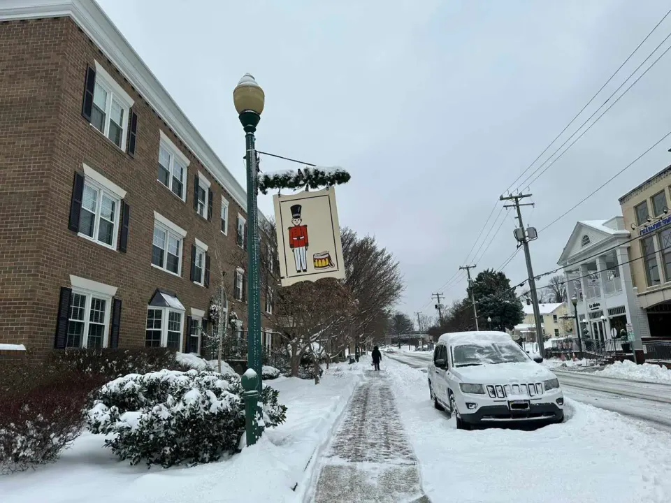 Toy soldier flag hangs over a snowy Church Street in Vienna (staff photo by Angela Woolsey)