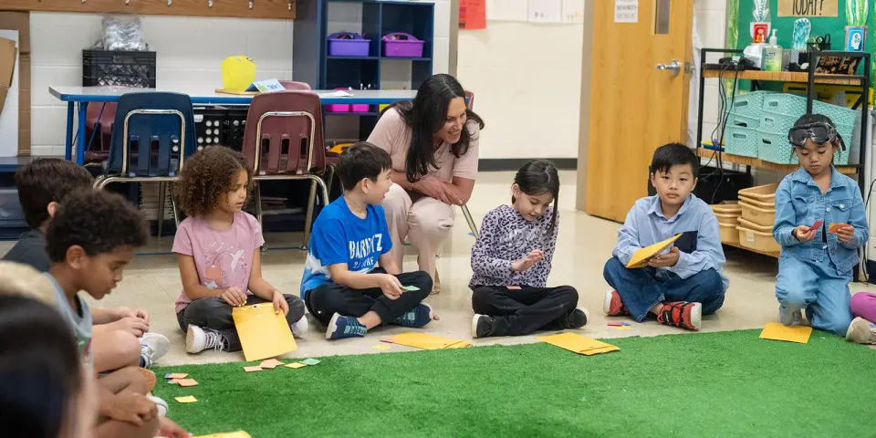 A principal looks over a child's shoulder