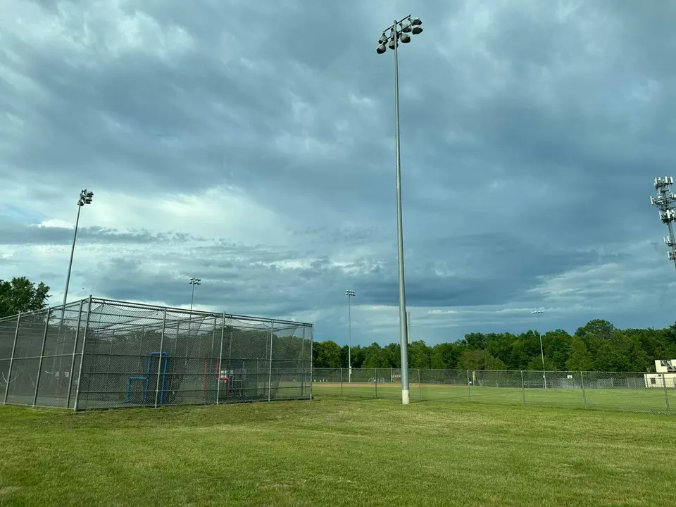 Clouds fill the sky over lights at Stratton Woods Park’s baseball field in Herndon (staff photo by Angela Woolsey)