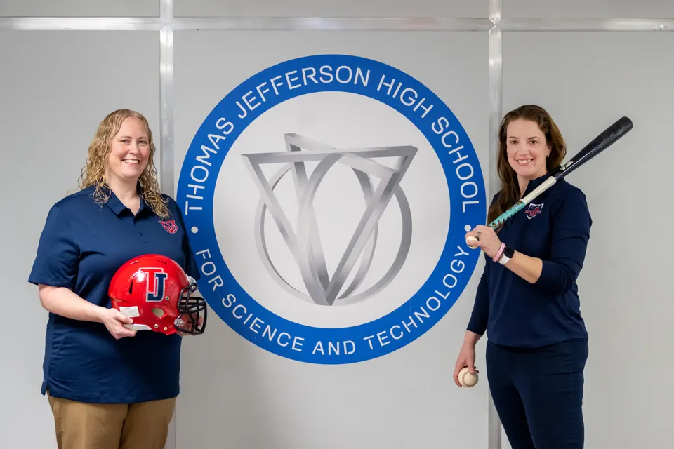 Rachel Worsham and Jennifer Hammond stand by the side of a TJ school mural.