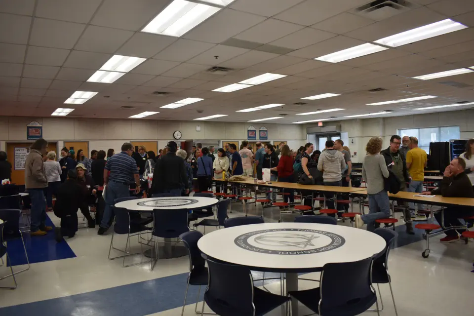 A wide shot of TJHSST alumni and former staff members in the cafeteria.