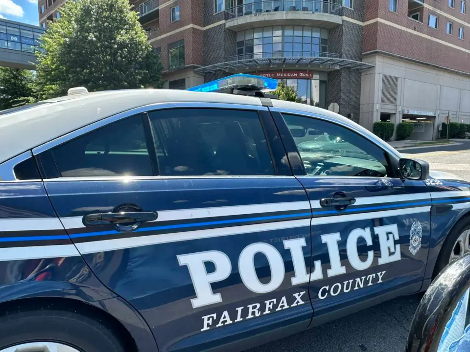 A Fairfax County police car with lights on at the Mosaic District (staff photo by Angela Woolsey)