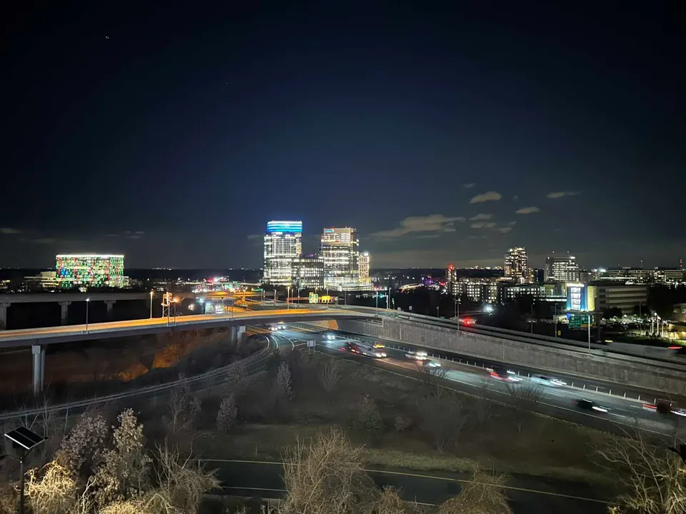 Drivers on I-495 pass the Tysons skyline at night (staff photo by Angela Woolsey)