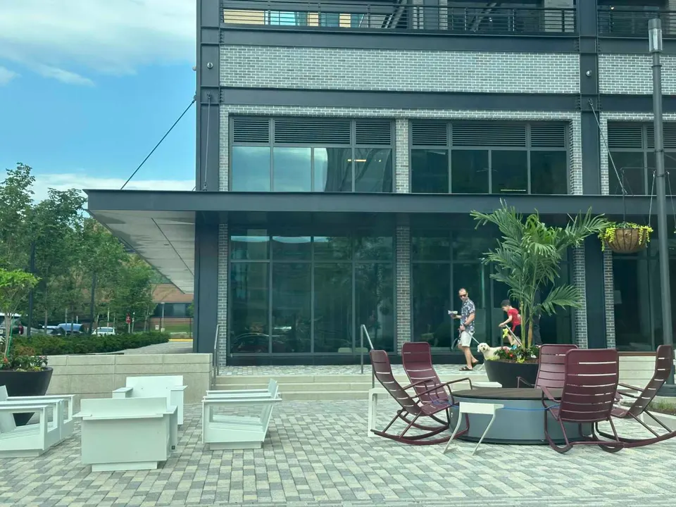 Man walks dog past outdoor seating in the expansion of Reston Town Center (staff photo by Angela Woolsey)