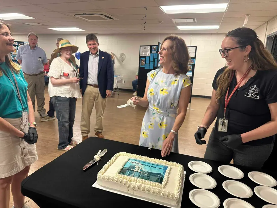 Vienna Mayor Linda Colbert cuts a cake to celebrate the Vienna Community Center’s 60th anniversary (staff photo by Angela Woolsey)